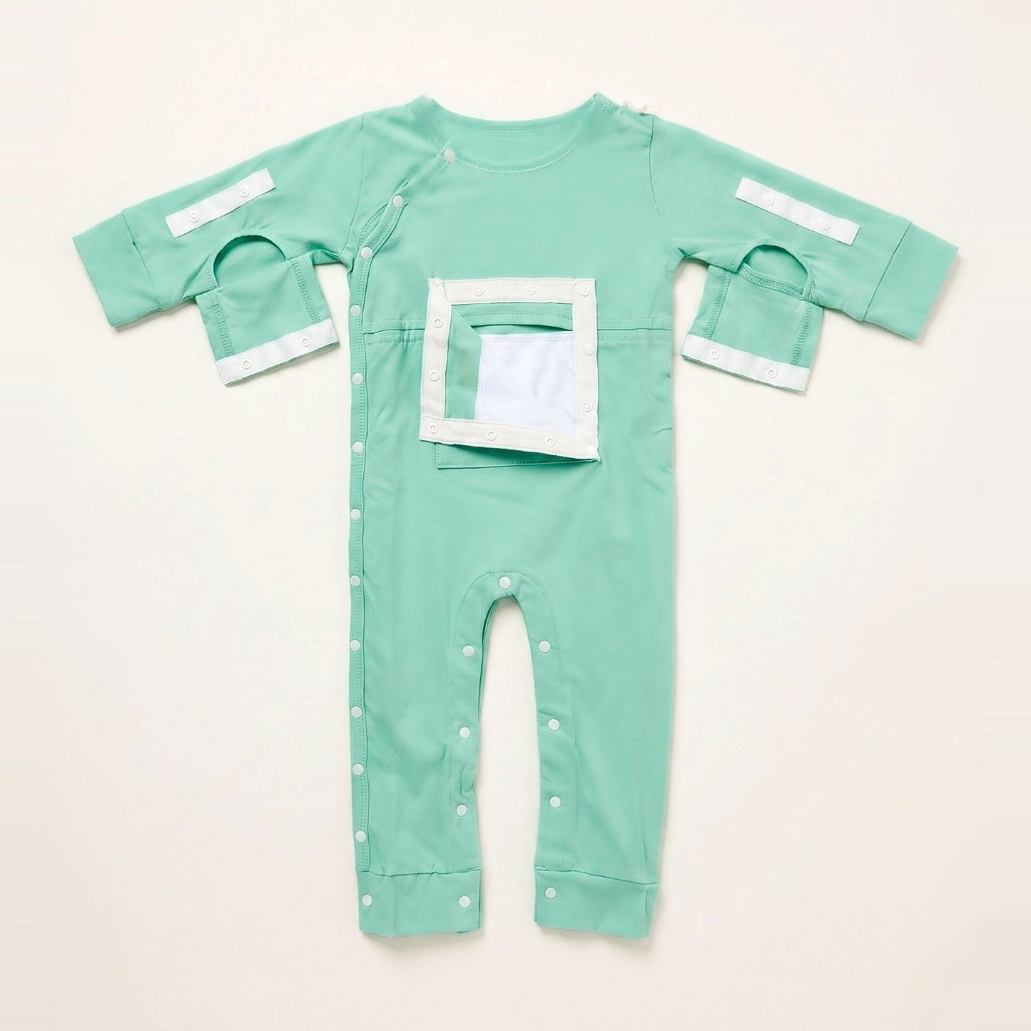 Calm Mint central line bodysuit with the PediaPouch chest pocket opened, showing the moisture-resistant interior lining