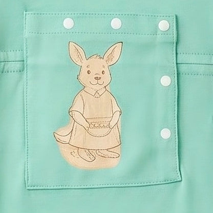 Close-up of the centred PediaPouch snap-close chest pocket with kangaroo detail on the Calm Mint bodysuit