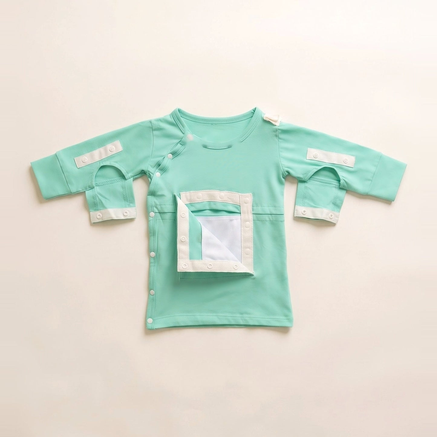 Calm Mint central line gown with the PediaPouch chest pocket opened, showing the moisture-resistant interior lining