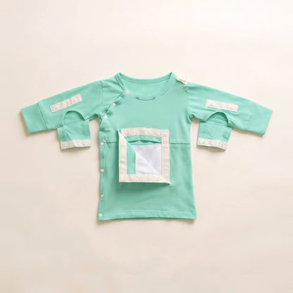 Calm Mint central line gown with the PediaPouch chest pocket opened, showing the moisture-resistant interior lining