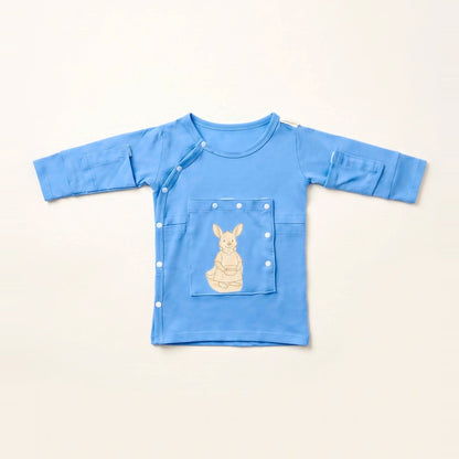 LineWear Chest Edition adaptive central line gown for newborns in Sky Lullaby blue, laid flat with the PediaPouch chest pocket closed