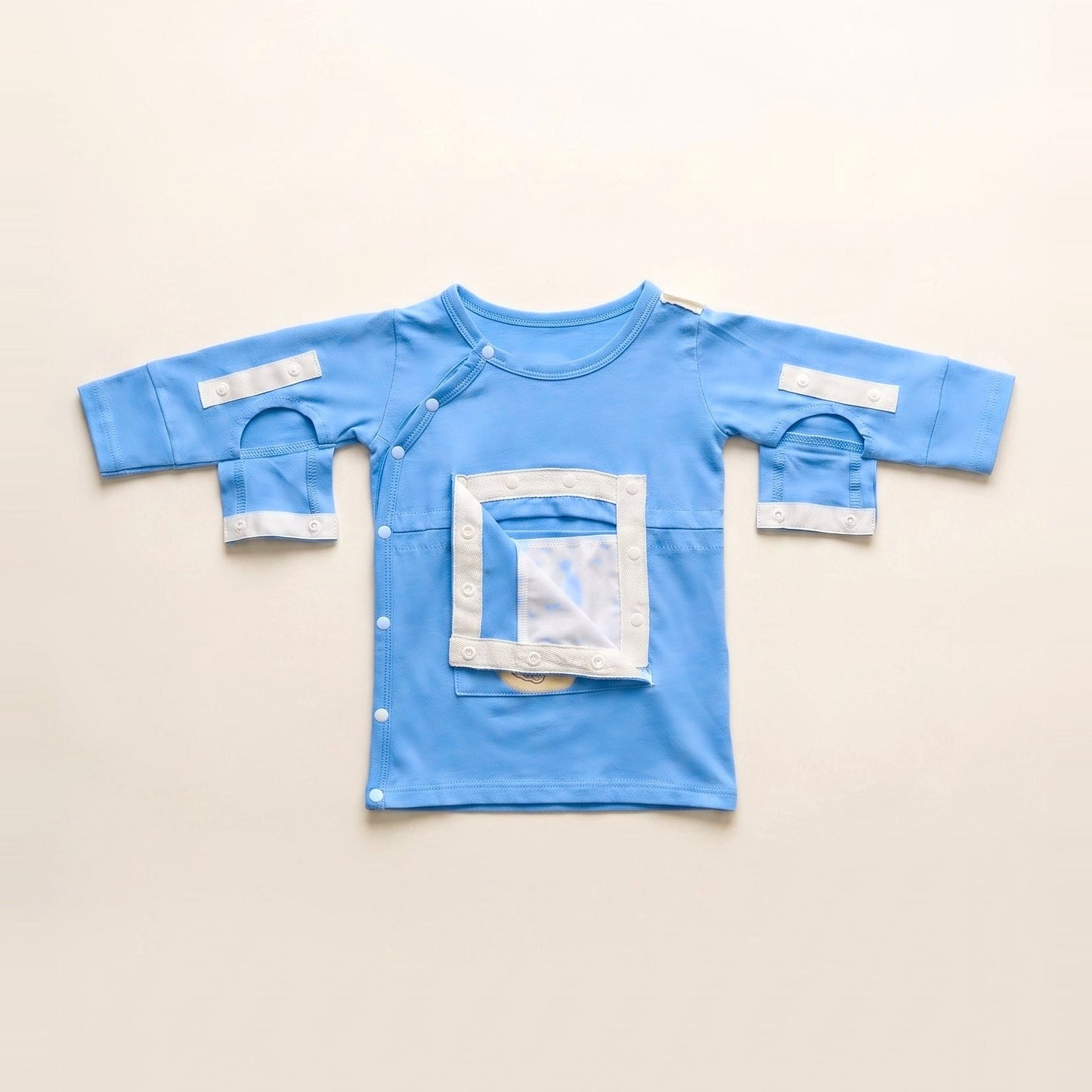 Sky Lullaby central line gown with the PediaPouch chest pocket opened, showing the moisture-resistant interior lining