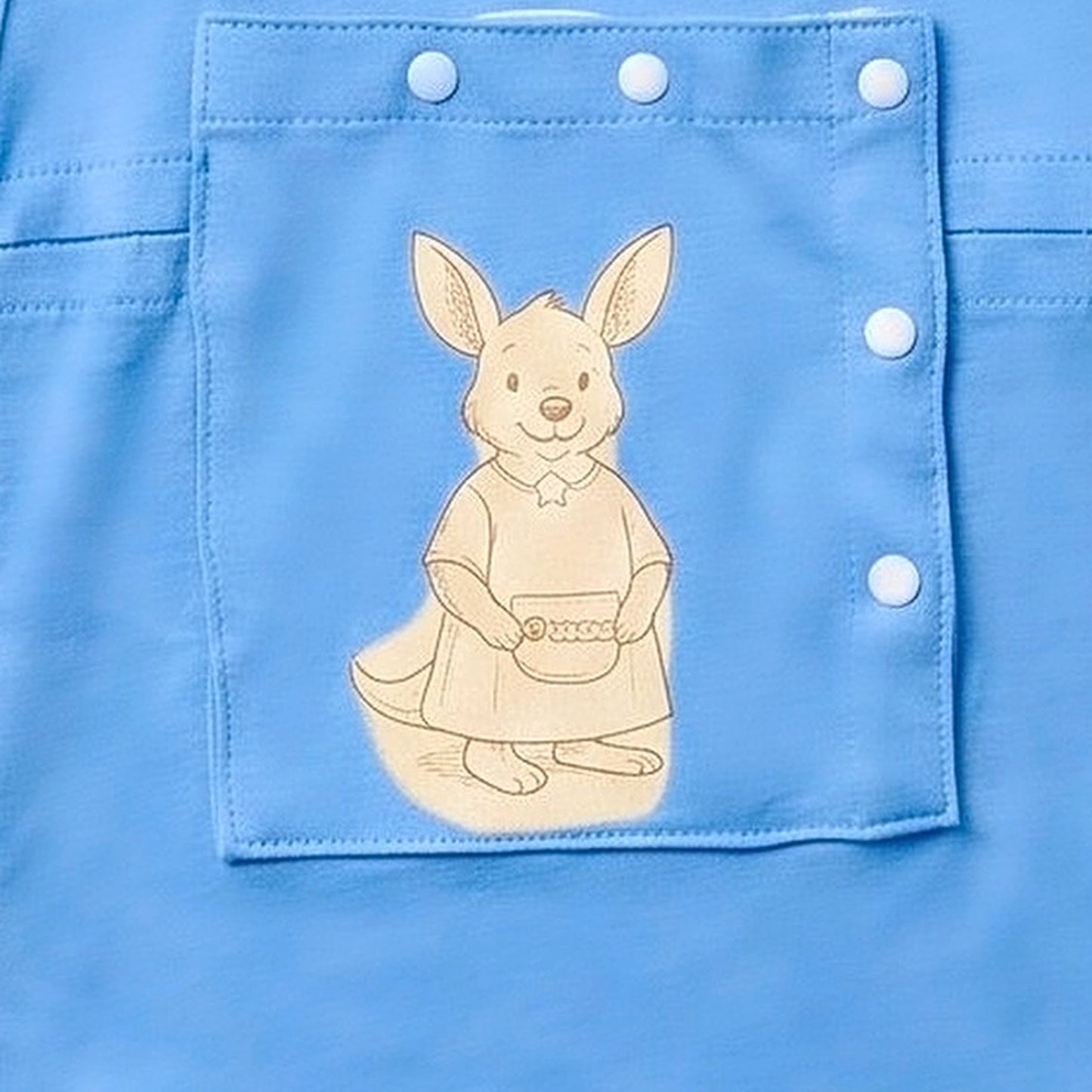 Close-up of the centred PediaPouch snap-close chest pocket with kangaroo detail on the Sky Lullaby infant gown