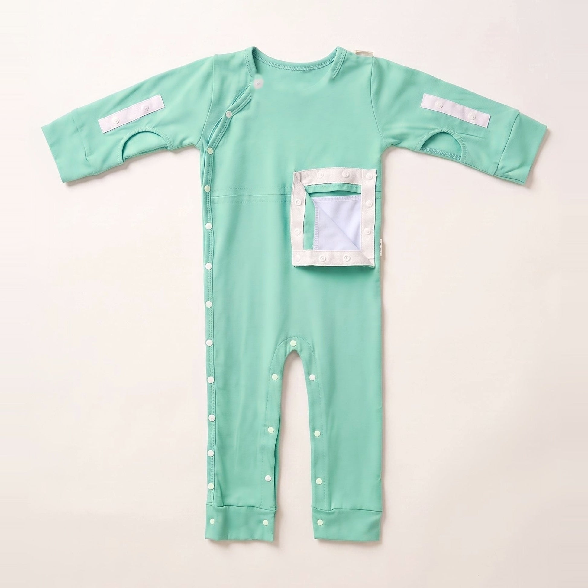 Calm Mint G/J tube bodysuit with the PediaPouch opened, showing the moisture-resistant interior lining