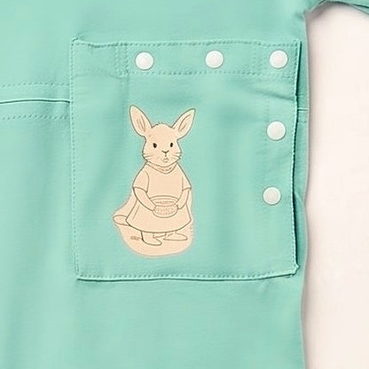 Close-up of the PediaPouch snap-close tube pocket with kangaroo detail on the Calm Mint bodysuit