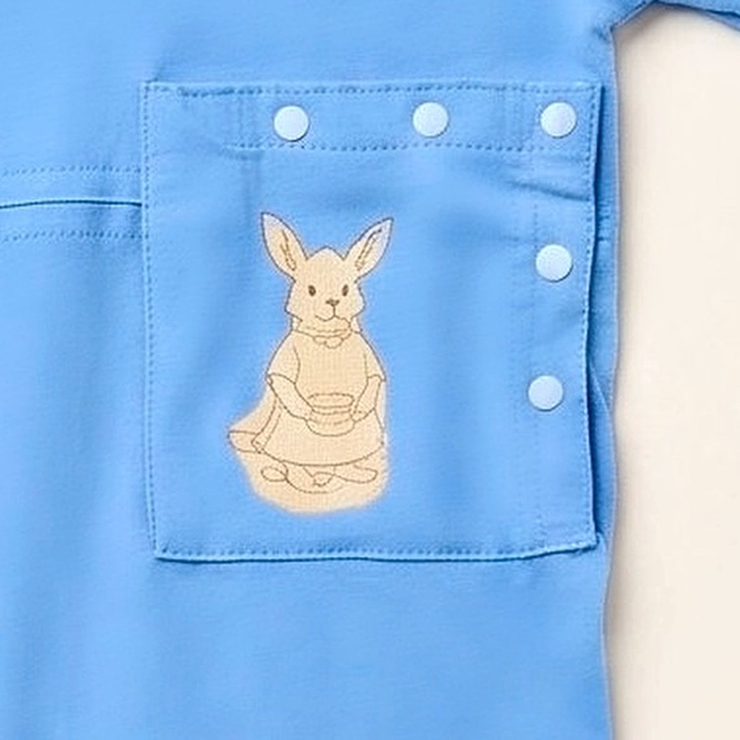 Close-up of the PediaPouch snap-close tube pocket with kangaroo detail on the Sky Lullaby bodysuit