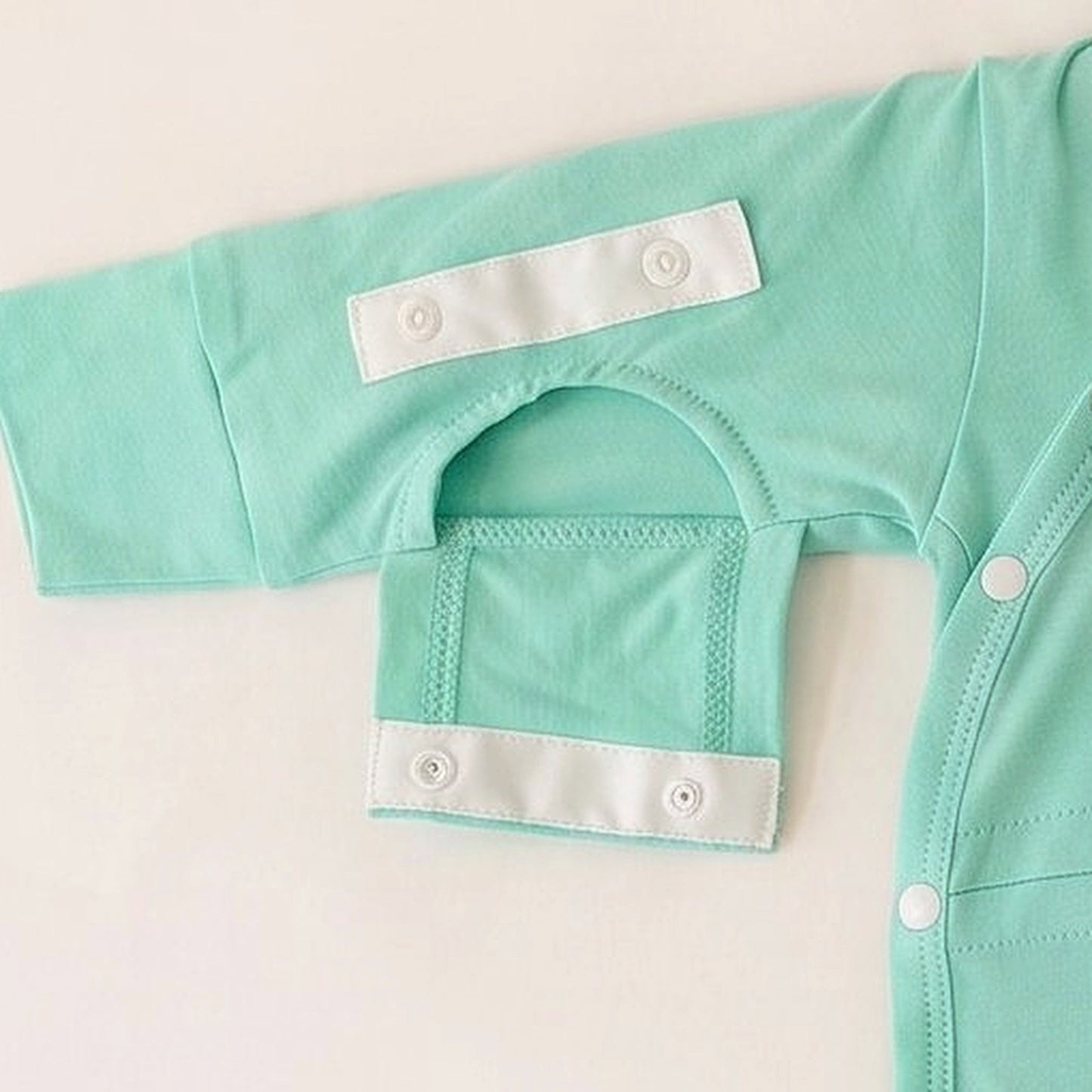 Dual Arm Access sleeve opening snapped open for IV, PICC line, or blood draw access on the Calm Mint garment