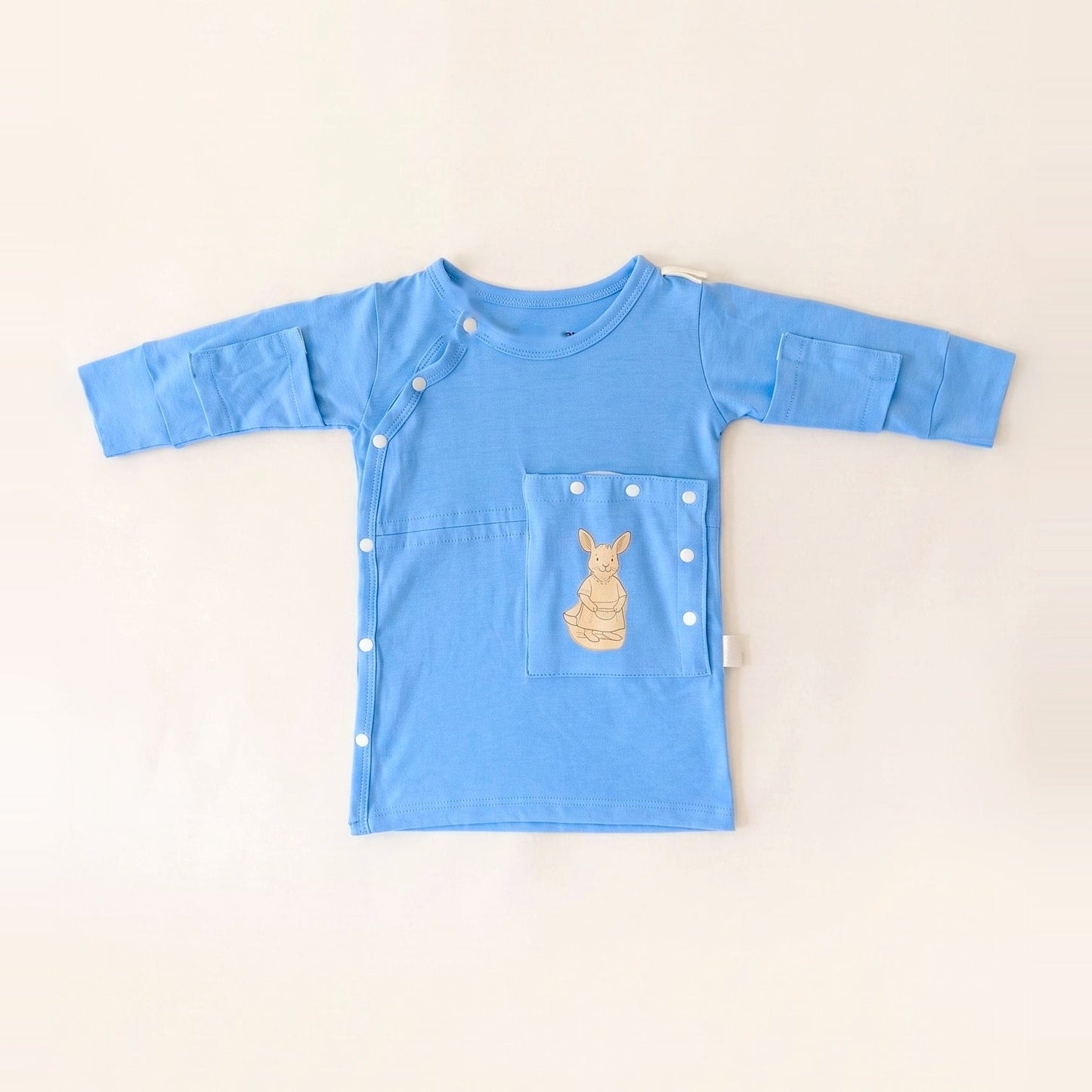 TubeWear adaptive G/J tube gown for newborns in Sky Lullaby blue, laid flat with the PediaPouch tube pocket closed