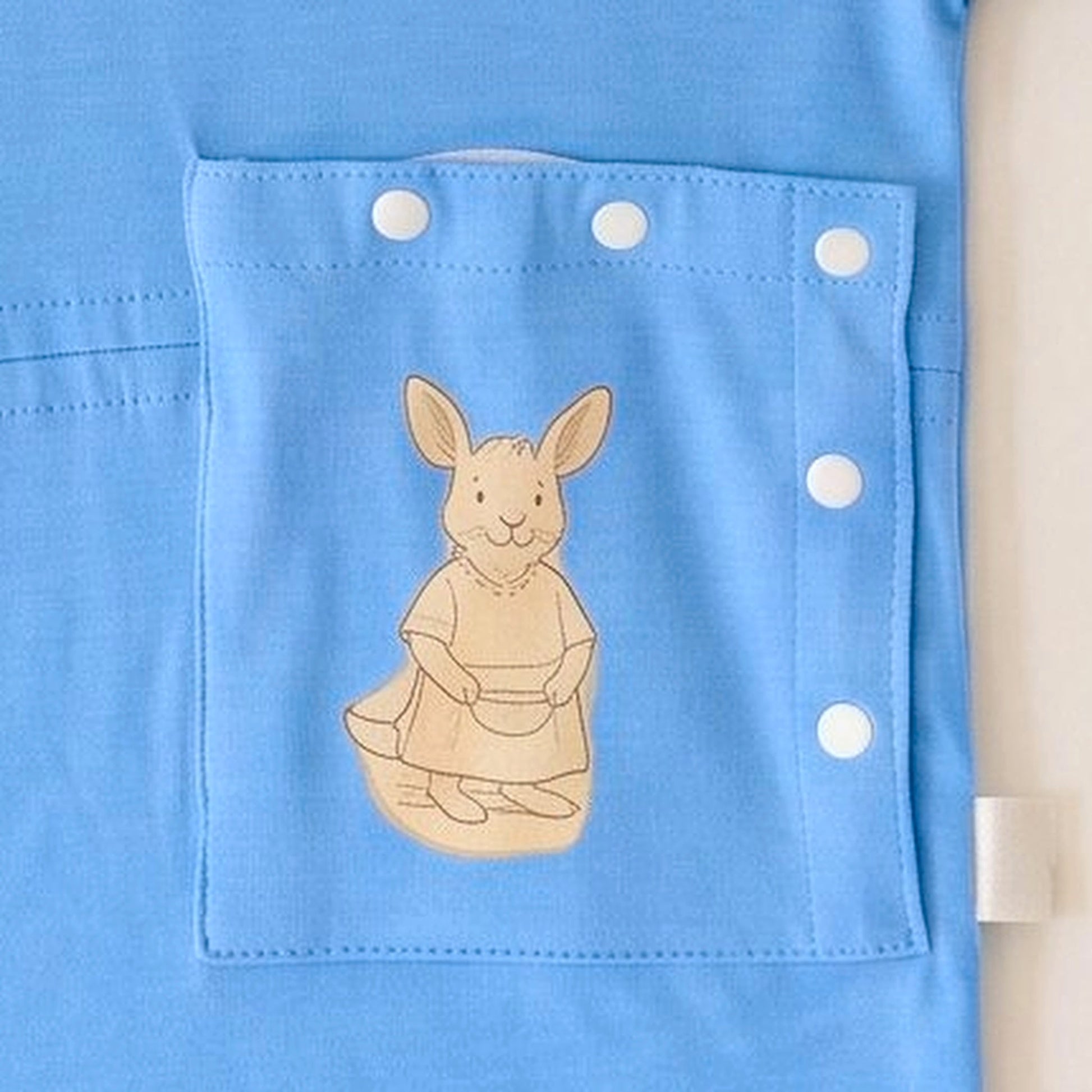 Close-up of the PediaPouch snap-close tube pocket with kangaroo detail on the Sky Lullaby infant gown